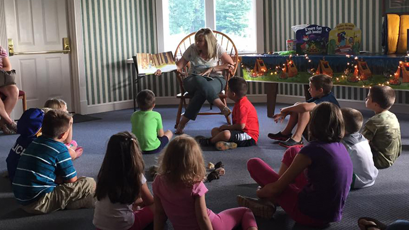 Reading a book to a group of children.